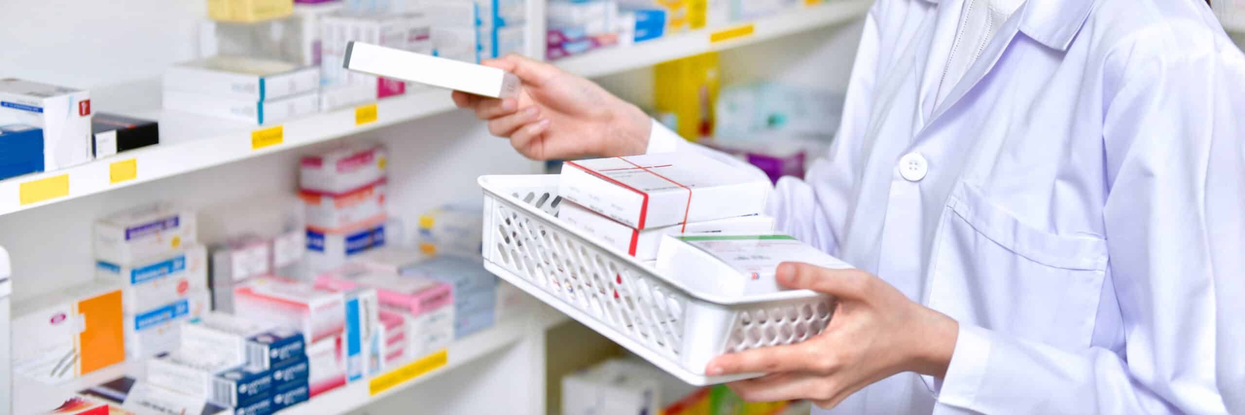 Pharmacist chemist woman standing refills the shelves with new s